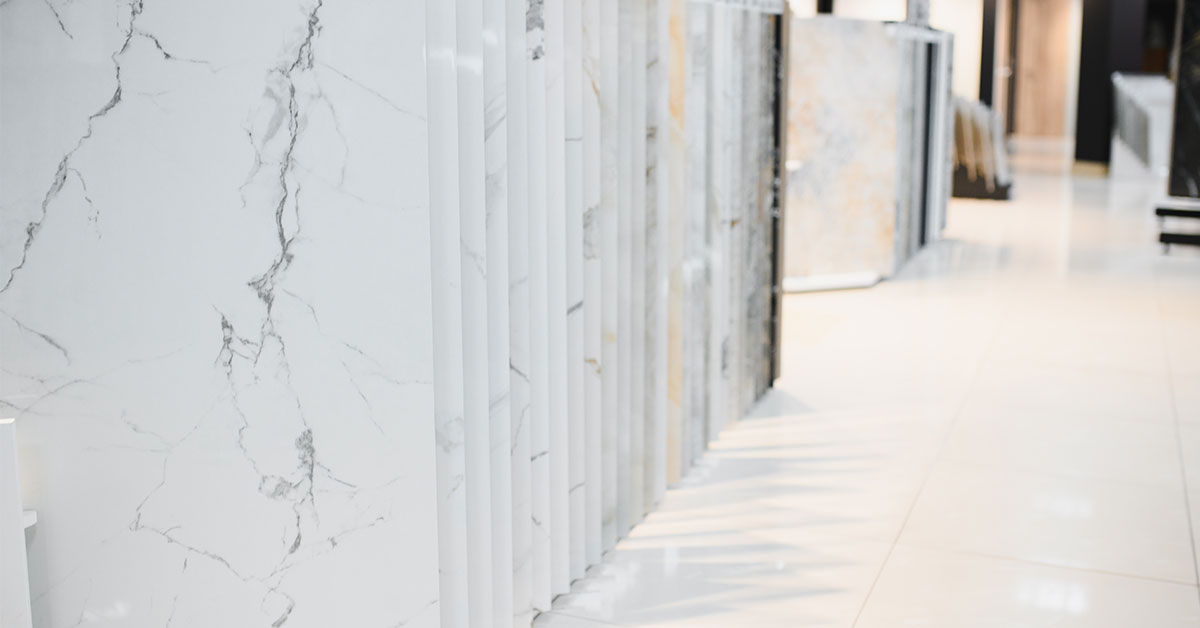 Various types of white marble slabs displayed in stone showroom including Carrara, Calacatta, and other white marble varieties with different veining patterns for selection