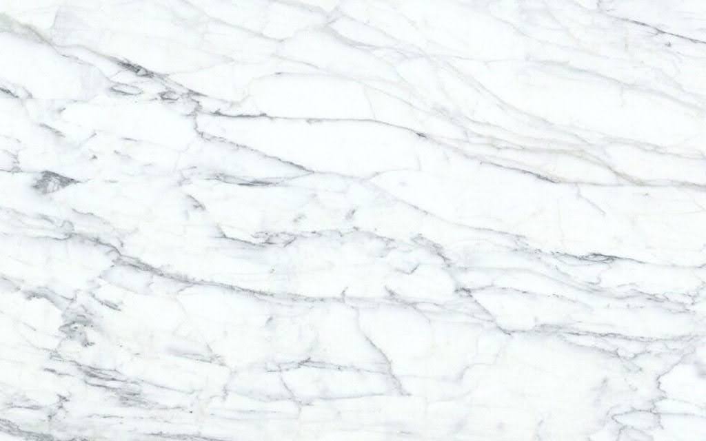 Close-up of Calacatta marble showing bold gray veining patterns on bright white background with irregular flowing lines
