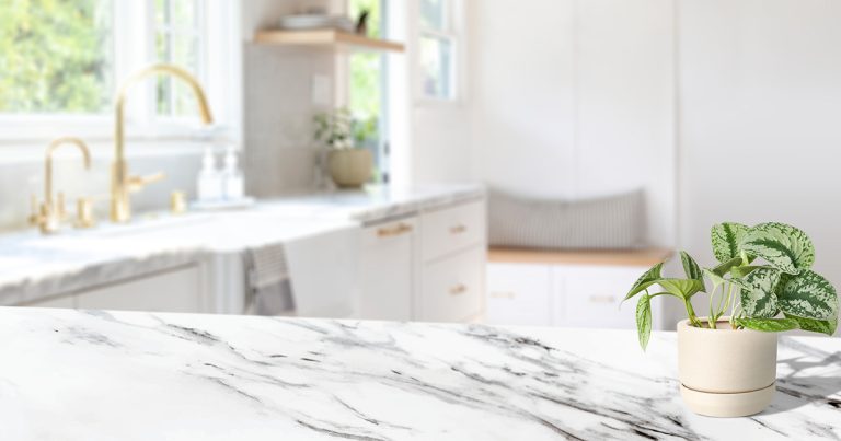 White marble countertop with bold gray veining in a bright kitchen, showing the natural beauty and aesthetic appeal of marble as a countertop material.